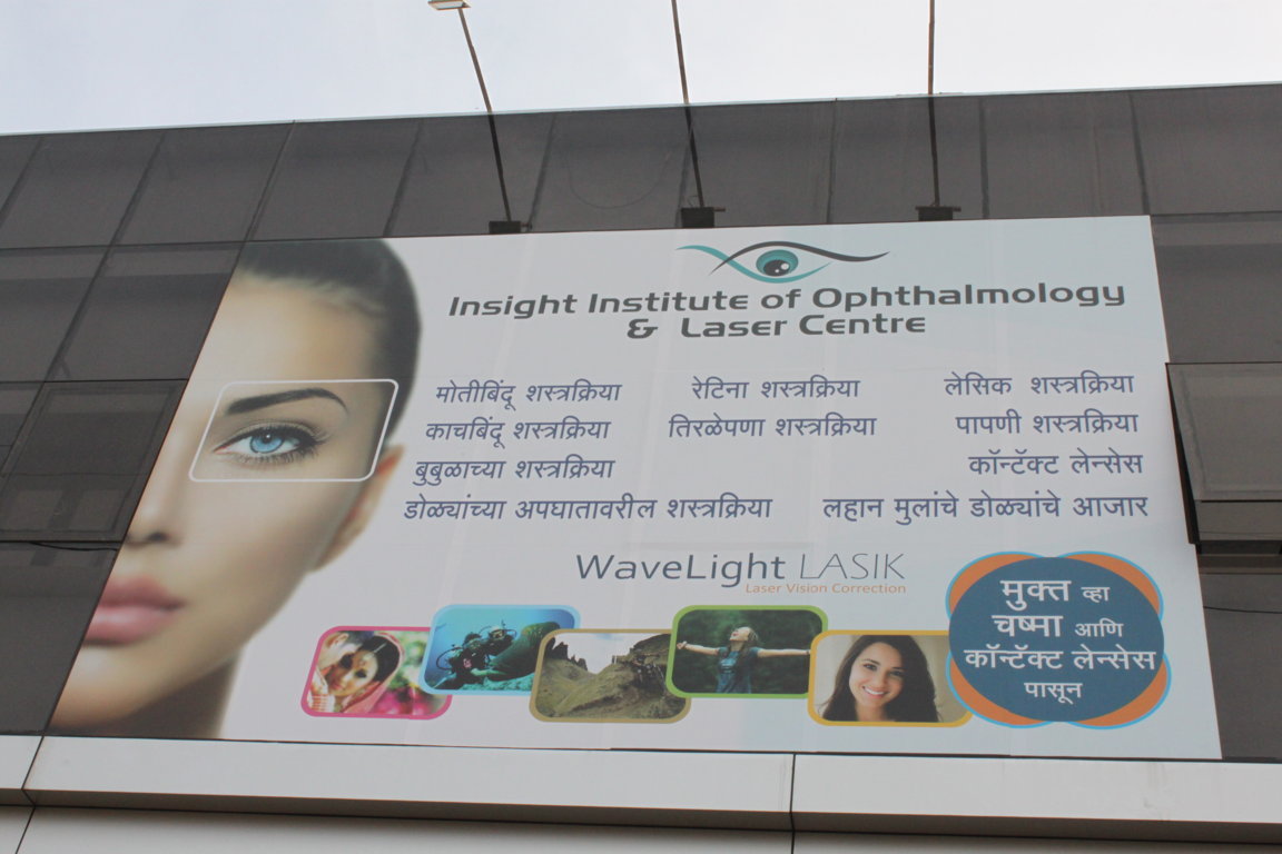 Building-mounted Insight Institute of Ophthalmology and Laser Centre billboard listing core services including LASIK, cataract and retina surgery